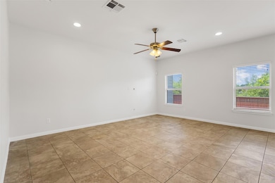 Empty room with ceiling fan, light tile patterned