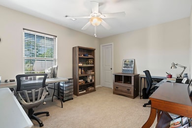 Office space featuring light colored carpet and ce