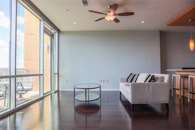 Living area featuring dark wood-style floors, a wall of windows, recessed lighting, and a ceiling fan