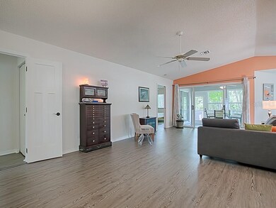 Living room opens to glass enclosed lanai with view of preserve
