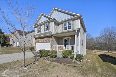 View of front of house with driveway, stone siding