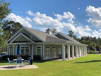 Rear view of house with a lawn, a patio, and frenc