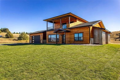 Rear view of property featuring a yard and an attached garage