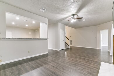 Beyond the foyer and split staircase, you'll find yourself in the heart of this home with a generously sized family room that offers a lighted ceiling fan, recessed mantle lighting, and breakfast bar seating that extends into the kitchen.
