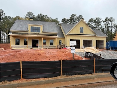 View of front of home featuring board and batten siding, a chimney, covered porch, and a garage