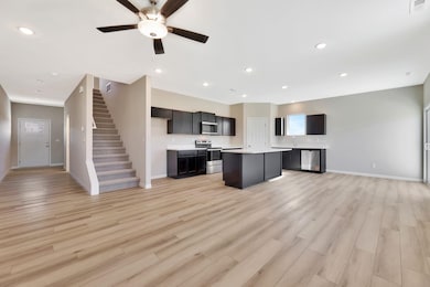 Kitchen featuring open floor plan, light countertops, appliances with stainless steel finishes, a center island, and recessed lighting