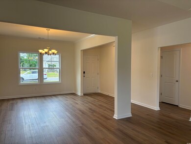 Foyer entrance featuring a chandelier, dark wood finished floors, crown molding, and baseboards