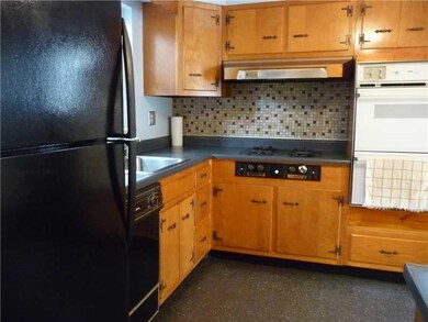 Kitchen. Double oven and gas cooktop with tile bac