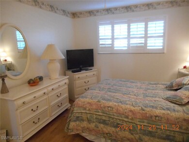 Bedroom with multiple windows and dark wood-style