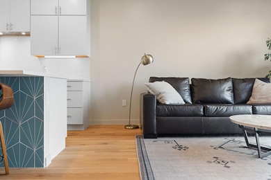 Living room with baseboards and light wood-type f