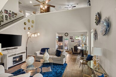 The captivating living area features a view of the second story and boasts high ceilings, creating a spacious and airy atmosphere.