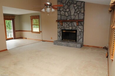 Living room features fireplace and opens to breakfast dining overlooking the large deck and landscaped lawn.