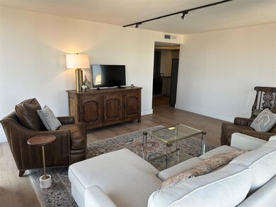Living area featuring rail lighting and wood finished floors