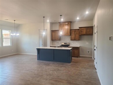 Kitchen with a center island with sink, pendant li