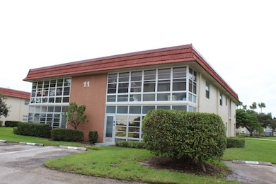 View of building exterior featuring uncovered parking