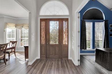 Foyer featuring ornamental molding, dark wood fini