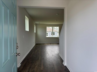 Corridor featuring dark wood-style flooring and baseboards