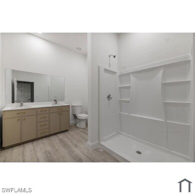 Bathroom featuring double vanity, toilet, wood fin