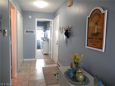 Hallway with baseboard heating and light tile floors