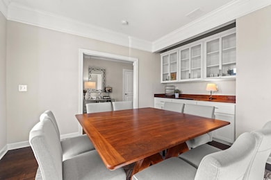Dining space featuring crown molding and dark wood