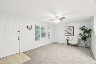 Entrance foyer with ceiling fan, light colored ca