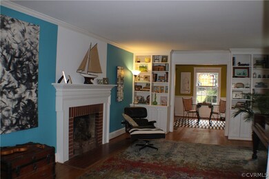 Light, bright living room with built in bookcases, wood burning fireplace, crown molding & hardwood floors!