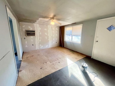Living Room with a wall unit AC and ceiling fan