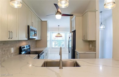 Kitchen with pendant lighting, light stone counter