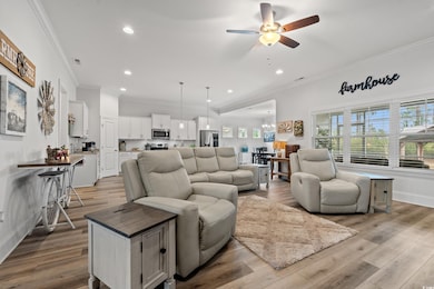 Living room with ornamental molding, ceiling fan w