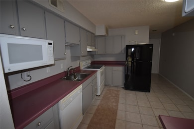 This kitchen features gray cabinets, offering ampl