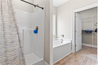 Bathroom featuring a stall shower, wood finished f