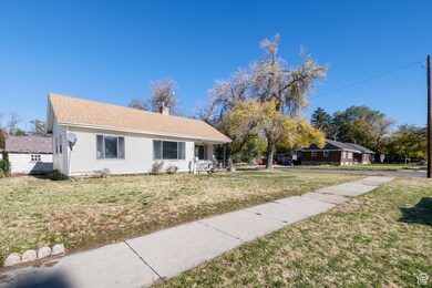 Ranch-style home with a porch, a front yard, a chimney, and roof with shingles