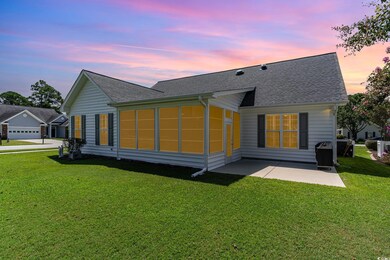 Back house at dusk with a garage and a yard
