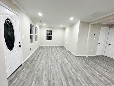 Foyer featuring ornamental molding and light wood-