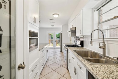 This kitchen has it all- pantry, stone counters, gas stove, built in microwave, bar area, stainless appliances.