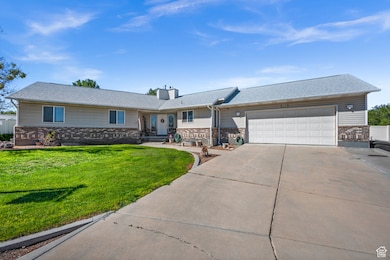 Ranch-style house with driveway, a garage, a chimney, a front yard, and brick siding
