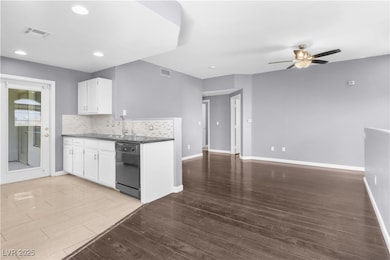 Kitchen with black dishwasher, ceiling fan, white