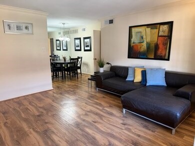 A spacious living and dining area with Laminate wo