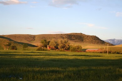 Looking south across hay fields, buildings and Rok