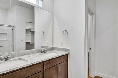Bathroom featuring double vanity, a shower, and a sink