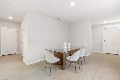 Dining room with light wood finished floors, baseboards, and recessed lighting