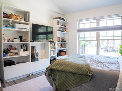 Bedroom featuring lofted ceiling and wood finished floors