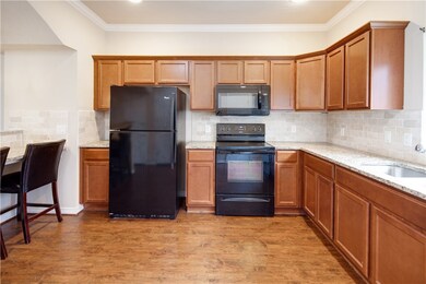 Kitchen featuring a sink, black appliances, brown