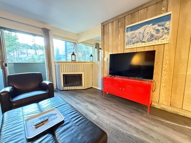 Living room with LVP flooring, wood walls and views to Canyon ski slopes