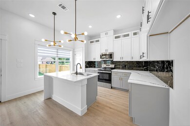 Kitchen with an open layout featuring sleek white
