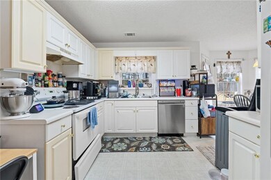 Kitchen with sink, a textured ceiling, stainless s