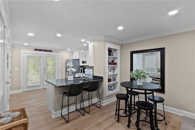 Kitchen featuring white cabinetry, a kitchen bar,