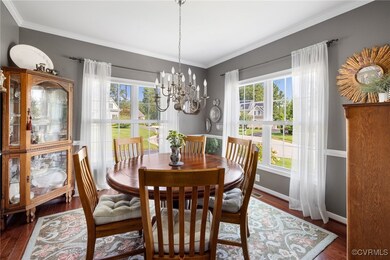 Dining room with a notable chandelier, dark hardwo