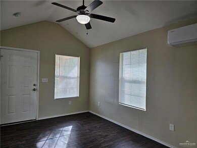 Spare room featuring dark hardwood / wood-style flooring, a wealth of natural light, and lofted ceiling
