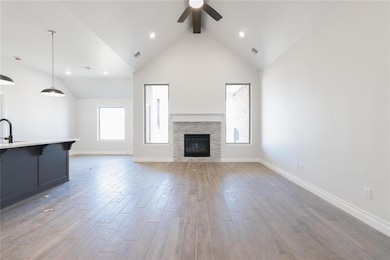 Unfurnished living room featuring ceiling fan, a f